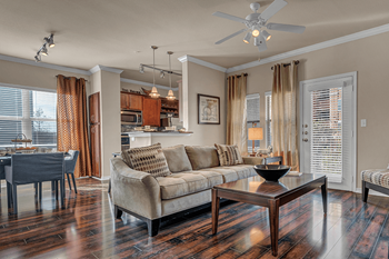 A modern living room with a brown coffee table and a beige couch.